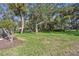 Expansive backyard with lush lawn, mature trees, and a screened-in lanai, perfect for outdoor entertaining and relaxation at 13747 Forest Ridge Ct, Hudson, FL 34667