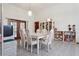Formal dining area with white table and chairs, tile flooring, and bright lighting at 13747 Forest Ridge Ct, Hudson, FL 34667