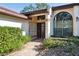 Inviting entryway with decorative iron gate, stone walkway, and well-maintained landscaping at 13747 Forest Ridge Ct, Hudson, FL 34667