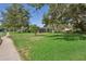 Spacious front yard with mature trees and lush green grass, offering a serene setting and enhanced privacy at 13747 Forest Ridge Ct, Hudson, FL 34667