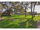 Lush green front lawn of the home, shaded by mature trees, offering a serene and welcoming exterior at 13747 Forest Ridge Ct, Hudson, FL 34667