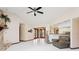 Bright living room with white tile floors, stone fireplace and fan with lights at 13747 Forest Ridge Ct, Hudson, FL 34667