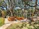 Outdoor picnic area with multiple picnic tables, a grill, and lush greenery, perfect for community gatherings at 13747 Forest Ridge Ct, Hudson, FL 34667