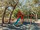 Community playground with a slide, swings, and picnic tables, providing a fun and safe play area for children at 13747 Forest Ridge Ct, Hudson, FL 34667
