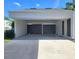Carport features a gray concrete floor, security gate, and a side door to enter the home at 14113 Cypress Cir, Tampa, FL 33618