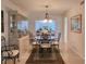 Bright dining room with glass table, modern chandelier, display cabinet and a view to the kitchen at 14113 Cypress Cir, Tampa, FL 33618