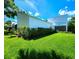Home exterior with an attached 2-car carport, white facade, lush lawn, and manicured landscaping at 14113 Cypress Cir, Tampa, FL 33618