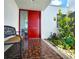 Front entrance featuring a red door, brick flooring and lush plants at 14113 Cypress Cir, Tampa, FL 33618