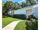 Bright home featuring lush lawn, walkway, and tropical palm trees at 14113 Cypress Cir, Tampa, FL 33618
