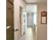 Hallway featuring doorway to bathroom and mirror reflecting the shower area at 14113 Cypress Cir, Tampa, FL 33618