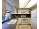 Bright kitchen featuring white cabinetry, tile floors and a large sink overlooking the yard at 14113 Cypress Cir, Tampa, FL 33618