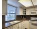 Well-lit kitchen featuring white cabinetry, solid surface countertops, and a window with blinds at 14113 Cypress Cir, Tampa, FL 33618