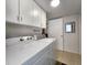 Functional laundry room boasts white cabinets and modern washer and dryer for efficient chore management at 14113 Cypress Cir, Tampa, FL 33618