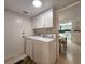 Convenient laundry room with washer, dryer, white cabinets, and access door at 14113 Cypress Cir, Tampa, FL 33618