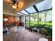 Enclosed patio with tile floor, glass top table and chairs, and views of the backyard at 14113 Cypress Cir, Tampa, FL 33618