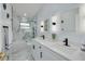 Bright bathroom featuring double vanity, decorative mirrors, and shower-tub combo with tile surround at 1608 Carlos Ave, Clearwater, FL 33755