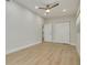 A well-lit bedroom featuring wood-look flooring, ceiling fan, and closet with bright-white doors at 1608 Carlos Ave, Clearwater, FL 33755
