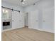 A bedroom boasts a barn door to the bathroom, wood-look flooring and three bright-white doors at 1608 Carlos Ave, Clearwater, FL 33755