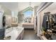 This bathroom has double sinks, hexagon tile flooring, a large mirror, a big window, and a walk-in closet at 1763 Pebble Hill Ct, Palm Harbor, FL 34683