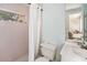 This bathroom includes a window, white tile, and a shower/tub combination with a curtain at 1763 Pebble Hill Ct, Palm Harbor, FL 34683