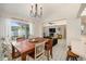 Bright dining room with pendant lighting, tile floors, table with seating for six, and open access to living area at 1763 Pebble Hill Ct, Palm Harbor, FL 34683