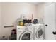 Functional laundry room with a washer, dryer, and storage for laundry supplies at 1763 Pebble Hill Ct, Palm Harbor, FL 34683
