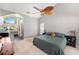 This main bedroom is equipped with a ceiling fan, carpeted floors, and an ensuite bathroom at 1763 Pebble Hill Ct, Palm Harbor, FL 34683