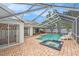 Inviting pool and spa surrounded by a screened enclosure, brick pavers, and a well-maintained patio at 1763 Pebble Hill Ct, Palm Harbor, FL 34683