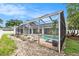 Backyard view of screened-in pool area with brick pavers, lounge chairs, and lush landscaping at 1763 Pebble Hill Ct, Palm Harbor, FL 34683