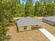 Aerial view of a yellow house with gray roof, a concrete driveway, and a green lawn at 19267 Wildwood Dr, Brooksville, FL 34601