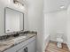 Bathroom with large mirror, modern vanity and shower with wood look floors at 19267 Wildwood Dr, Brooksville, FL 34601
