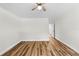 A bright, empty bedroom with wood-look flooring leading to an open door at 19267 Wildwood Dr, Brooksville, FL 34601