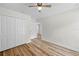 An ample bedroom features wood-look flooring, a ceiling fan and a double-door closet at 19267 Wildwood Dr, Brooksville, FL 34601