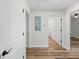 Hallway with hard surface floors, neutral paint, and doors leading to the bathroom and living room at 19267 Wildwood Dr, Brooksville, FL 34601