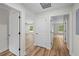 Hallway with doors leading to different rooms, wood look flooring and high ceilings at 19267 Wildwood Dr, Brooksville, FL 34601