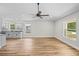 Bright living room with hard surface floors, neutral paint, modern ceiling fan, and open layout at 19267 Wildwood Dr, Brooksville, FL 34601