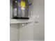 A gray water heater sits on a white shelf in the laundry space at 19267 Wildwood Dr, Brooksville, FL 34601