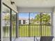 Peaceful screened balcony with a scenic view of the manicured lawn and surrounding landscape at 214 Meadow Ln # 214, Oldsmar, FL 34677