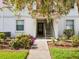 Exterior entrance to the condominium with lush landscaping and a blooming tree at 214 Meadow Ln # 214, Oldsmar, FL 34677