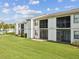 White condo building featuring screened patios and well-maintained green lawn at 214 Meadow Ln # 214, Oldsmar, FL 34677
