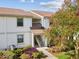 Two-story condo building with beautiful landscaping and a flowering tree in the front yard at 214 Meadow Ln # 214, Oldsmar, FL 34677