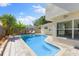 Beautiful backyard showcasing an in-ground pool, palm trees, and comfortable lounge area at 218 N Bay Hills Blvd, Safety Harbor, FL 34695