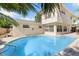 Spacious backyard with a sparkling in-ground pool, white stucco home, and lush tropical landscaping at 218 N Bay Hills Blvd, Safety Harbor, FL 34695