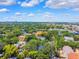 Extensive aerial showing the city, with many trees, and residential real estate below puffy clouds at 2404 W Jetton Ave, Tampa, FL 33629