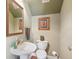 Powder room featuring pedestal sink, wood floors, ornate mirror, and decorative wall art at 2404 W Jetton Ave, Tampa, FL 33629