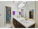 Bathroom featuring dual sinks with a large mirror, and doorways to adjacent rooms at 2404 W Jetton Ave, Tampa, FL 33629