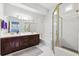 Bathroom featuring dual sinks, dark wood cabinets, gold fixtures, and a glass-enclosed shower at 2404 W Jetton Ave, Tampa, FL 33629