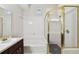 Bright bathroom featuring a combined tub and shower with elegant gold trim and white tile walls at 2404 W Jetton Ave, Tampa, FL 33629