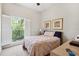 Cozy bedroom with neutral carpet, shuttered window with a view, and bed with light pink coverlet at 2404 W Jetton Ave, Tampa, FL 33629