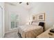 Cozy bedroom with neutral tones, a plush bed, and natural light streaming through shuttered windows at 2404 W Jetton Ave, Tampa, FL 33629